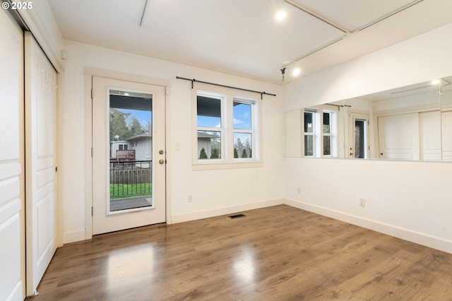 spare room with wood-type flooring and track lighting