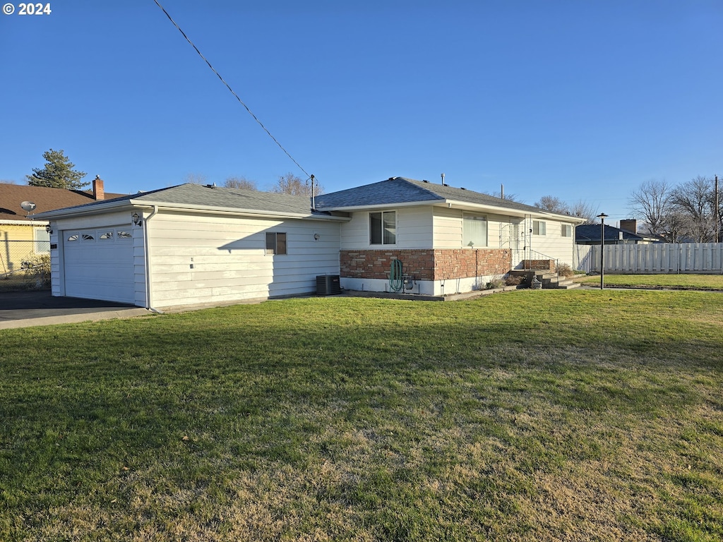 exterior space with a front yard, central AC, and a garage