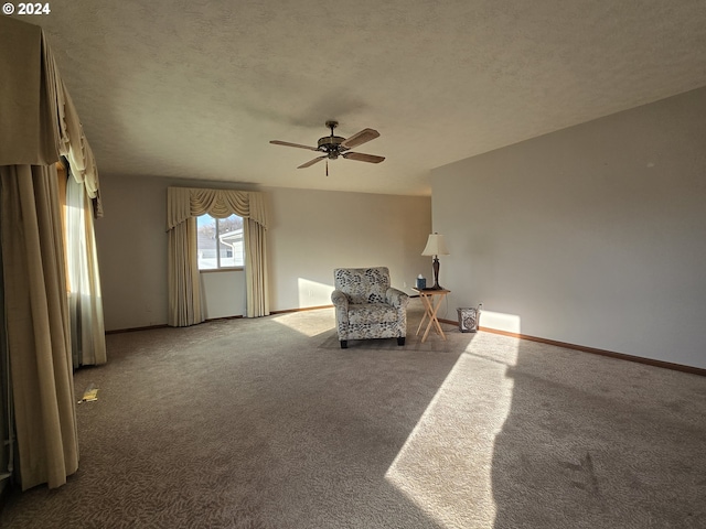 unfurnished room with a textured ceiling, carpet floors, and ceiling fan