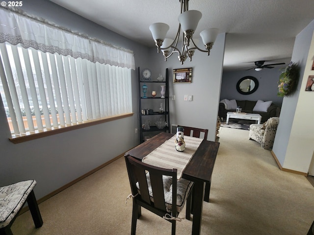 carpeted dining space featuring ceiling fan with notable chandelier and a textured ceiling