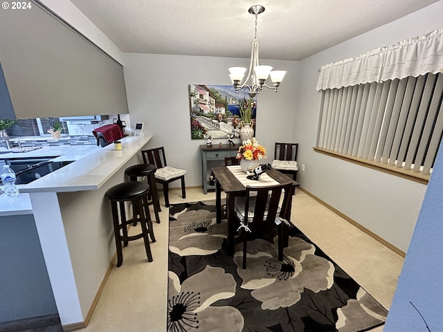 dining area with a textured ceiling, light colored carpet, and a notable chandelier