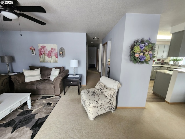 carpeted living room with sink, a textured ceiling, and ceiling fan