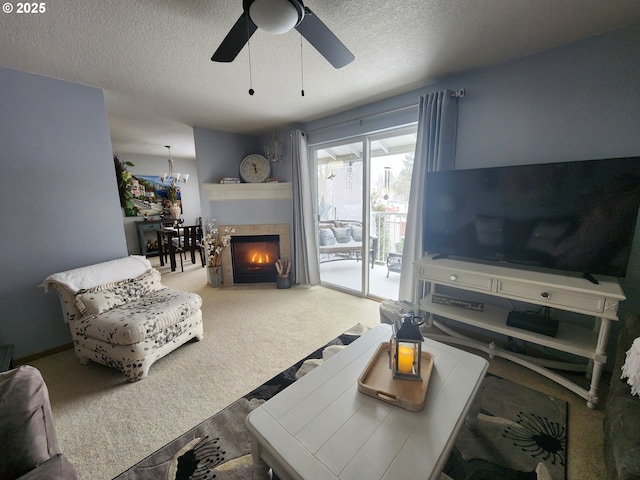 living room with ceiling fan, carpet floors, a textured ceiling, and a fireplace