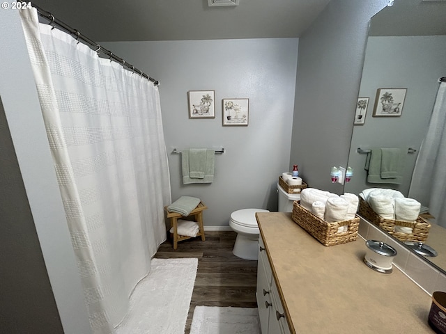 bathroom with toilet, vanity, and wood-type flooring