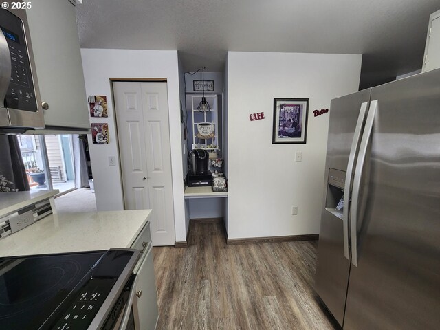 kitchen featuring backsplash, black stove, sink, gray cabinets, and stainless steel fridge