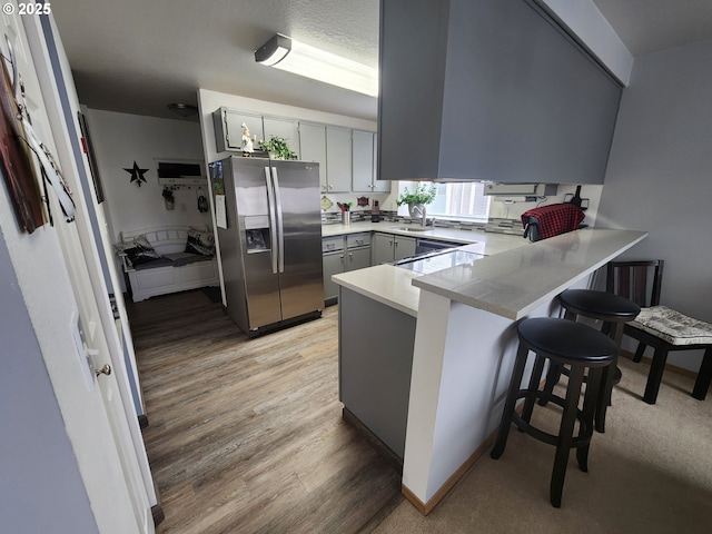 kitchen featuring appliances with stainless steel finishes, light hardwood / wood-style floors, gray cabinetry, and sink