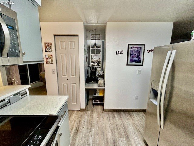 kitchen with light wood-type flooring and appliances with stainless steel finishes