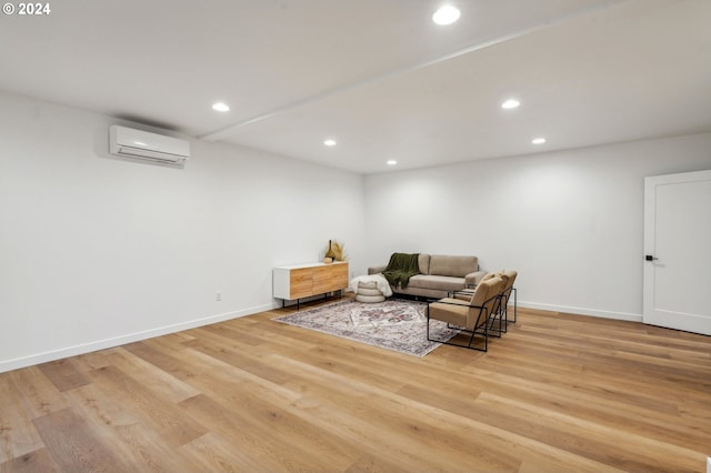 living area featuring light hardwood / wood-style floors and an AC wall unit