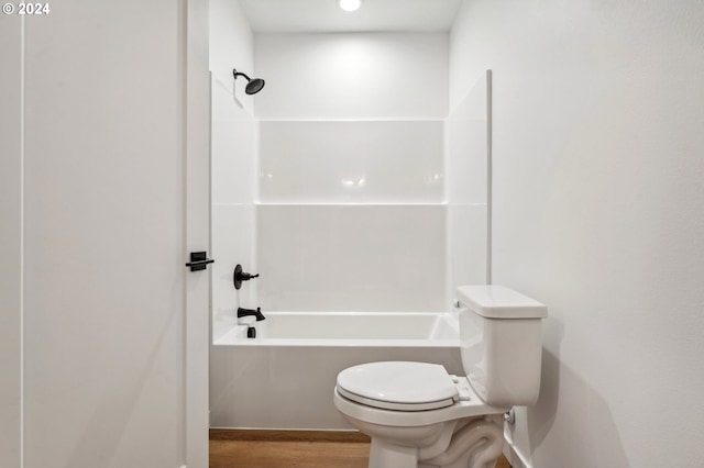 bathroom featuring toilet, wood-type flooring, and shower / washtub combination