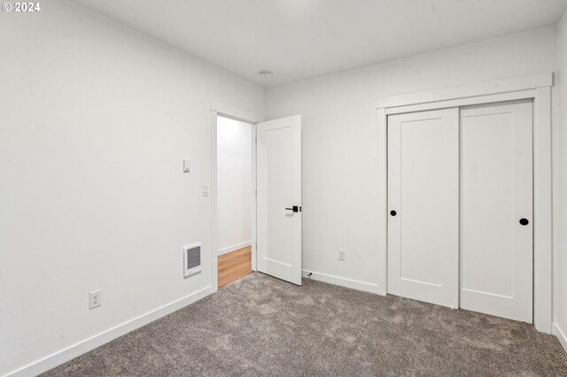 unfurnished bedroom with a closet and carpet floors