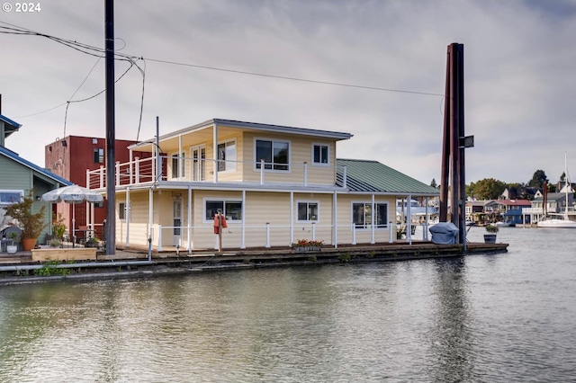 back of house with a water view and a balcony