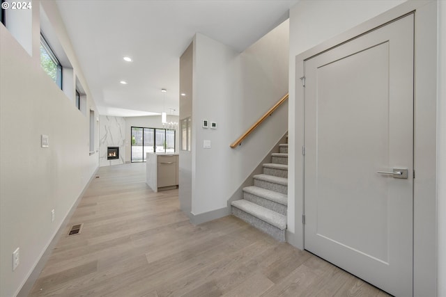 corridor featuring light hardwood / wood-style floors and a notable chandelier