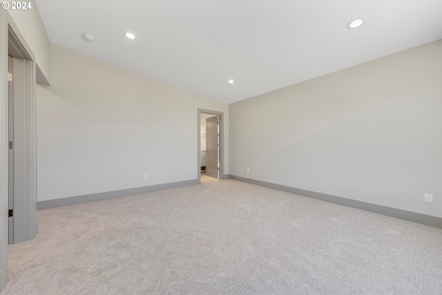 empty room featuring light carpet and vaulted ceiling