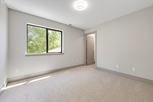 unfurnished room featuring light carpet