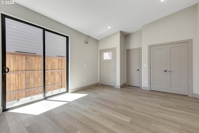 entryway with lofted ceiling and light wood-type flooring