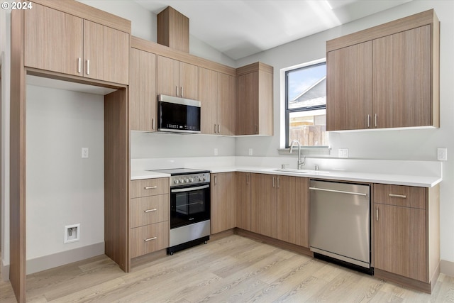 kitchen with light hardwood / wood-style floors, sink, stainless steel appliances, and light brown cabinets