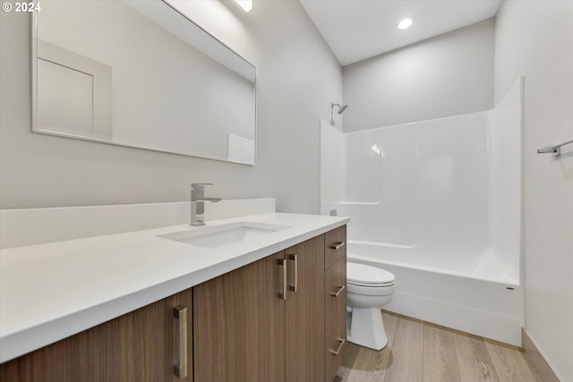 full bathroom with hardwood / wood-style floors, vanity, toilet, and shower / bathtub combination