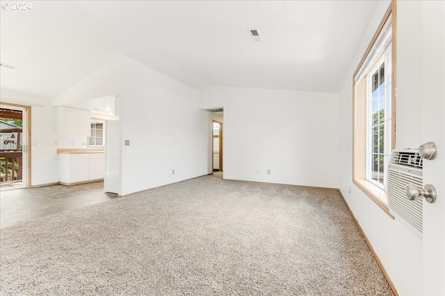 empty room featuring carpet and vaulted ceiling