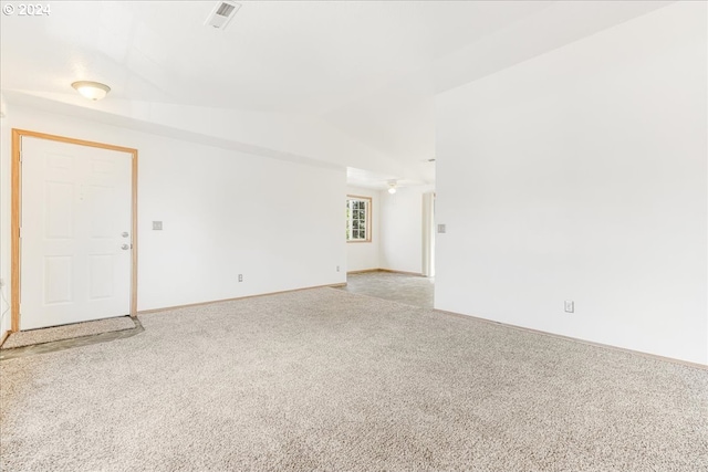 carpeted empty room with lofted ceiling