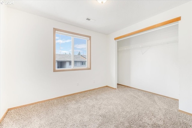 unfurnished bedroom featuring carpet and a closet