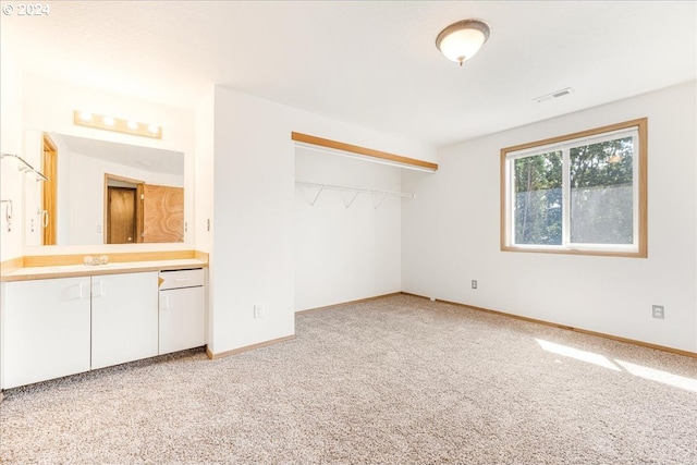 unfurnished bedroom with light carpet and a closet