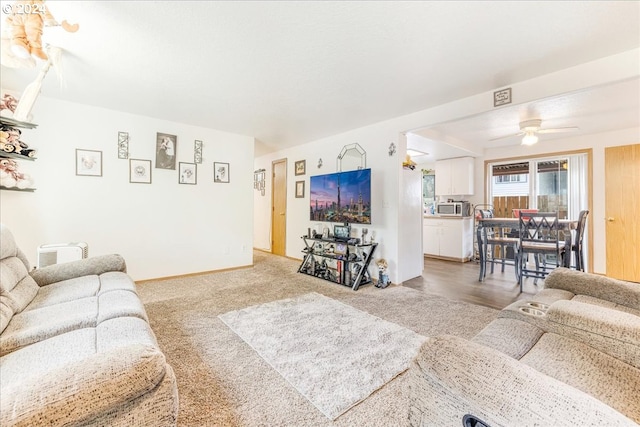 living room with ceiling fan and carpet flooring