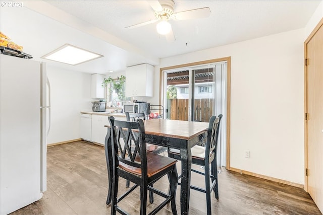 dining space with sink, light hardwood / wood-style floors, and ceiling fan