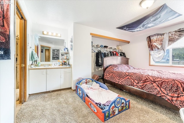 carpeted bedroom with a closet and a textured ceiling