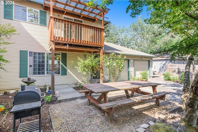 view of patio / terrace with a balcony, a garage, and grilling area