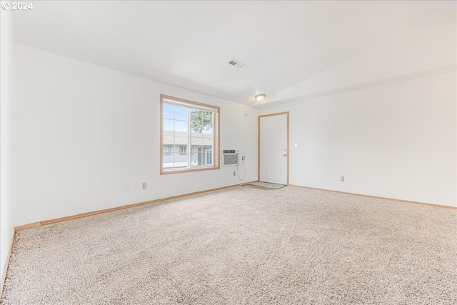 unfurnished room with carpet, vaulted ceiling, and a wall mounted air conditioner