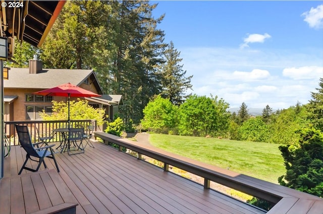 wooden deck featuring outdoor dining area and a yard