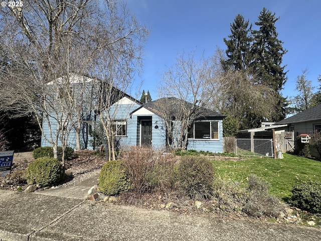 view of front of home with a front lawn and fence