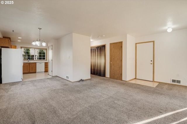 unfurnished living room with light colored carpet and a chandelier