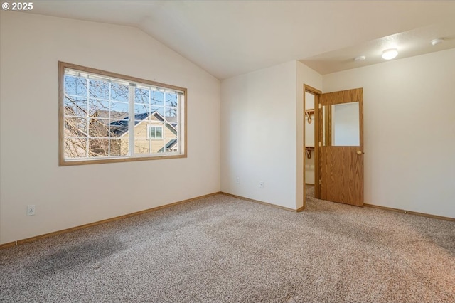 carpeted spare room with lofted ceiling