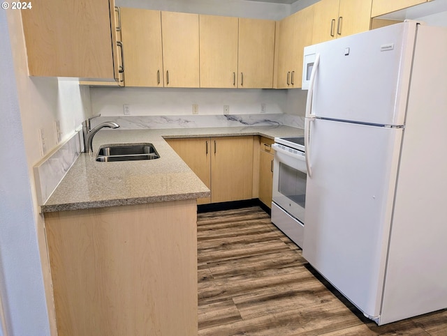 kitchen with sink, light brown cabinets, white appliances, and hardwood / wood-style flooring