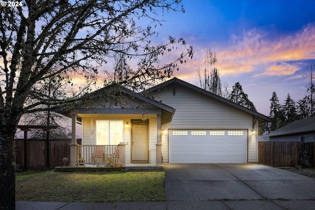 view of front facade featuring a porch, a garage, and a lawn