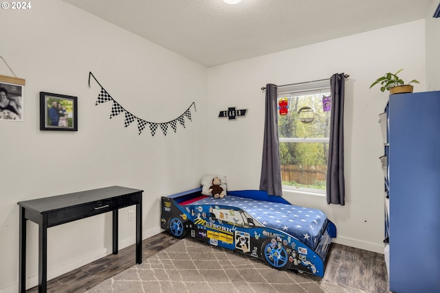 bedroom featuring hardwood / wood-style flooring and a textured ceiling