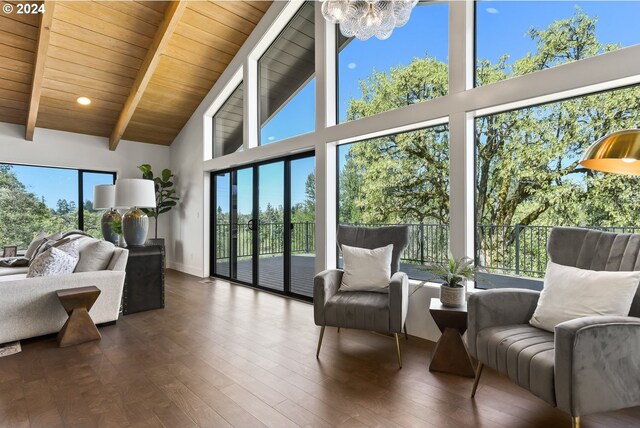 sunroom / solarium featuring vaulted ceiling with beams, an inviting chandelier, and plenty of natural light