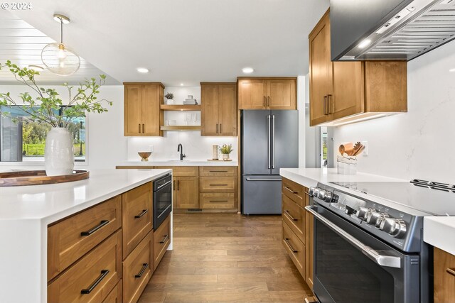 kitchen featuring pendant lighting, stainless steel appliances, plenty of natural light, and wall chimney exhaust hood