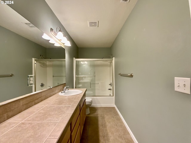 full bathroom featuring shower / bath combination with glass door, toilet, vanity, and tile patterned floors