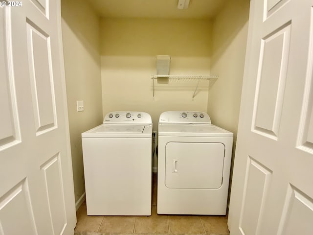 laundry room featuring light tile patterned floors and washer and clothes dryer