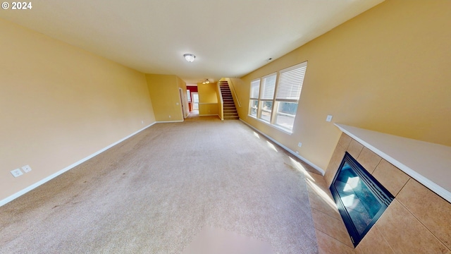 unfurnished living room featuring light colored carpet and a tile fireplace