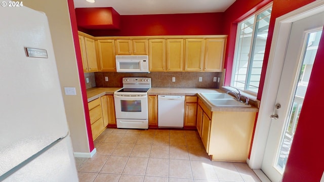 kitchen with backsplash, white appliances, sink, and a wealth of natural light