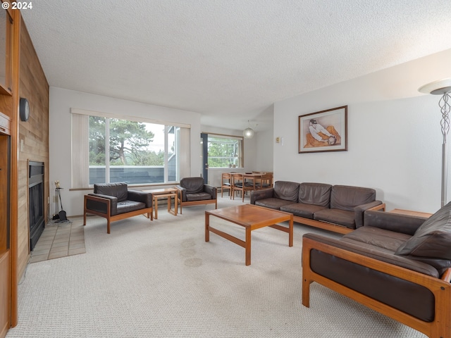 living room with light colored carpet, a textured ceiling, and a wealth of natural light