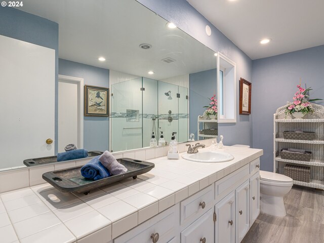 bathroom with walk in shower, toilet, vanity, and hardwood / wood-style flooring