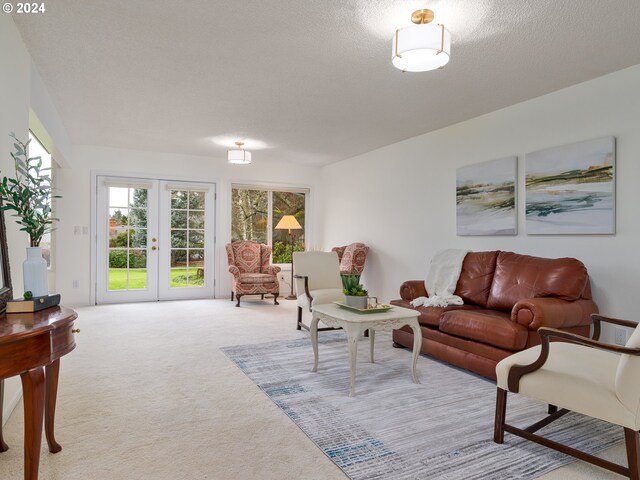 living room with light carpet, french doors, and a textured ceiling