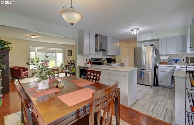 dining room with light wood-style floors and beverage cooler