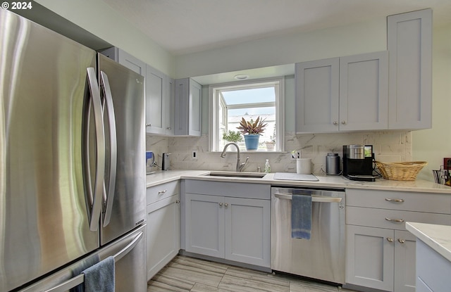 kitchen with appliances with stainless steel finishes, a sink, and decorative backsplash