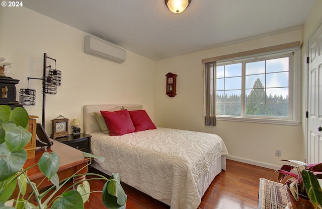 bedroom with baseboards, hardwood / wood-style floors, and a wall mounted AC