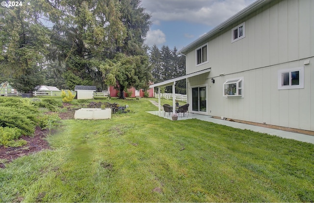 view of yard featuring a patio area, a shed, and an outdoor structure